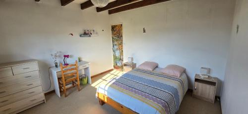 une chambre avec un lit, une commode et un bureau dans l'établissement Chambres de l'Ourbise, à Razimet