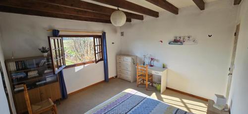 une chambre avec un lit, un bureau et une fenêtre dans l'établissement Chambres de l'Ourbise, à Razimet