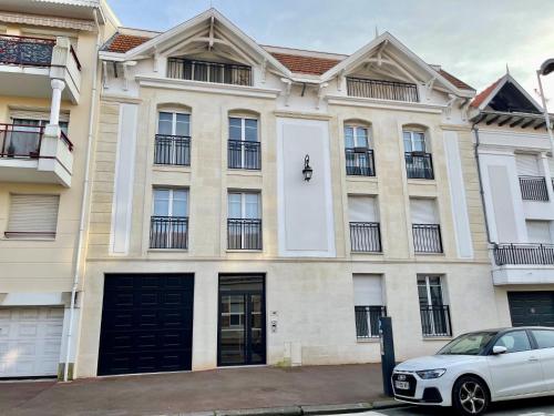 une voiture blanche garée devant un immeuble dans l'établissement Apartment Le 48 by Interhome, à Arcachon