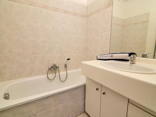 La salle de bains est pourvue d'un lavabo et d'une baignoire à côté d'un lavabo. dans l'établissement Studio Les Rives Latines-4 by Interhome, à Fréjus