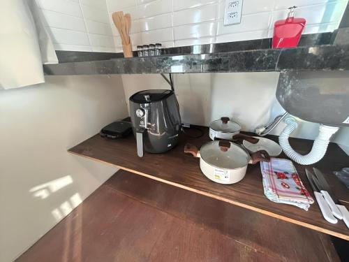 a kitchen shelf with a coffee pot and a mixer at Cabanas em Gostoso WindVacances in Touros