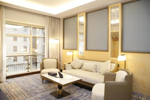 a living room with a couch and chairs and windows at MADEN Al Rawda مادن الروضة in Al Madinah