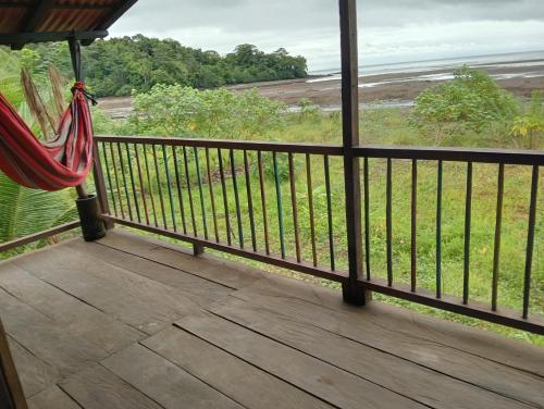 a porch with a hammock and a view of the ocean at casa guayaba lodge in Nuquí