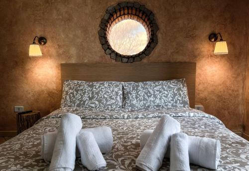 a bedroom with a bed with white pillows and a mirror at Guarda Che Luna in Sasso di Castalda