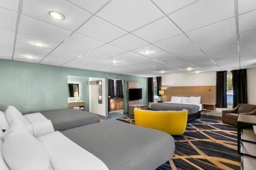 a hotel room with two beds and a yellow chair at Quality Inn Downtown Helen in Helen