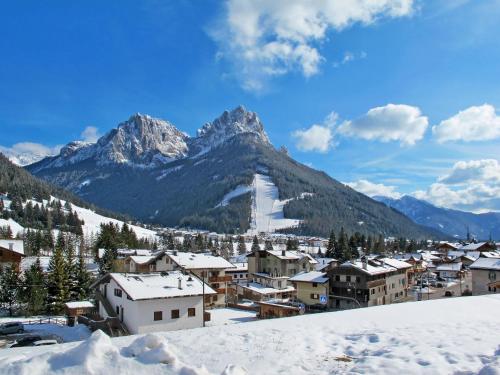 a village covered in snow with mountains in the background at Apartment Delago by Interhome in Pera