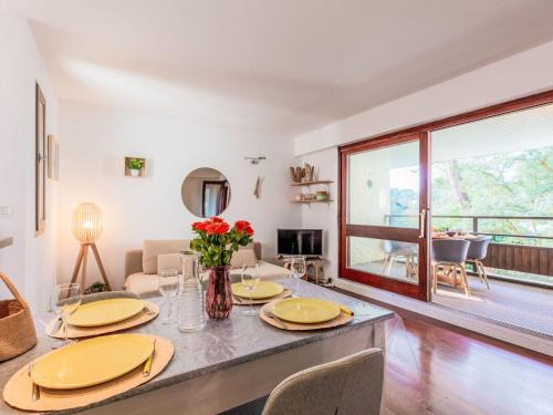 - un salon doté d'une table avec des assiettes et des fleurs dans l'établissement Apartment Pyrénées by Interhome, à Seignosse