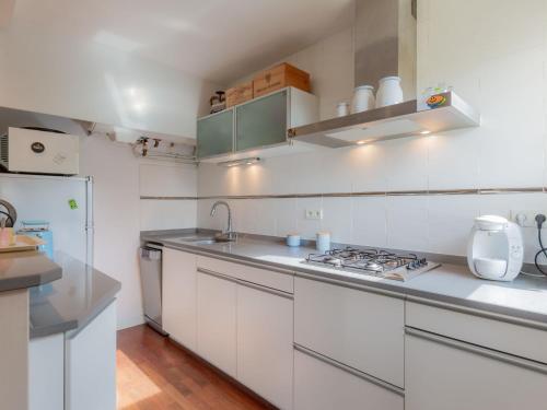 une cuisine blanche avec un évier et une cuisinière dans l'établissement Apartment Pyrénées by Interhome, à Seignosse