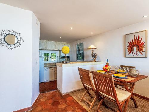 une cuisine et une salle à manger avec une table et des chaises dans l'établissement Apartment Village de Silhouette-6 by Interhome, à Grimaud