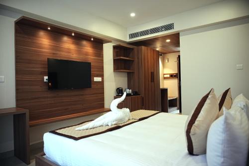 a bedroom with a bed with a swan decoration on it at Tranquil Riverview Inn in Kottayam