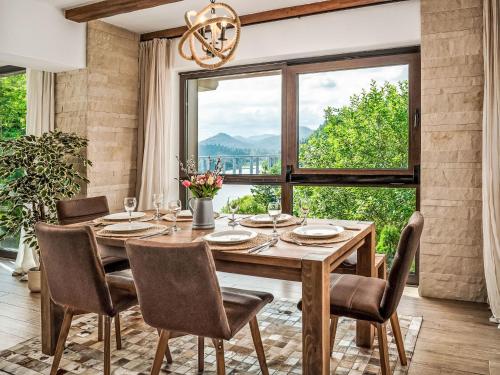 Un comedor con mesa y sillas y una gran ventana. en Villa Fužine by Interhome, en Fužine