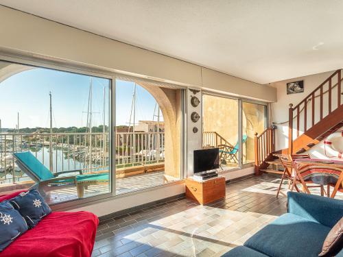 Il comprend un salon avec un canapé, une télévision et un balcon. dans l'établissement Apartment Port de la Gavine I-4 by Interhome, à Hyères