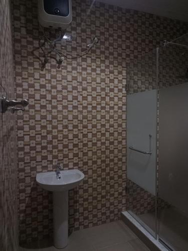a bathroom with a sink and a shower at Ja'Oak Hotel and Suites in Benin City