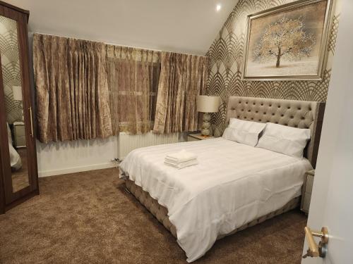 a bedroom with a large white bed in a room at CITY CENTRE LUXURY House WITH THREE VERY LARGE SIZE BEDROOMS in Belfast