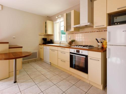 - une cuisine avec des appareils blancs et une table en bois dans l'établissement Holiday Home L'Evasion Bernerienne by Interhome, à La Bernerie-en-Retz