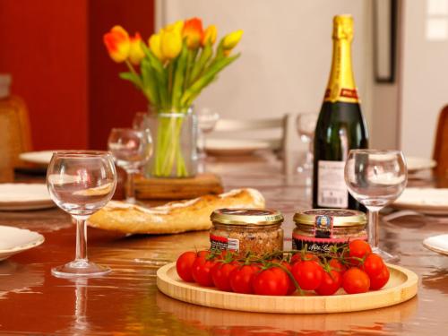 une table avec un plateau de tomates et une bouteille de vin dans l'établissement Holiday Home L'Evasion Bernerienne by Interhome, à La Bernerie-en-Retz