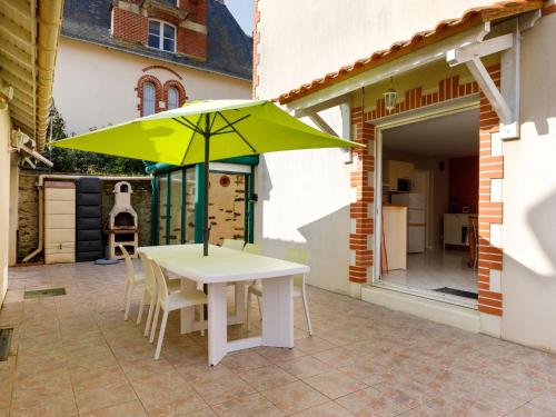 - une table avec un parasol vert sur la terrasse dans l'établissement Holiday Home L'Evasion Bernerienne by Interhome, à La Bernerie-en-Retz