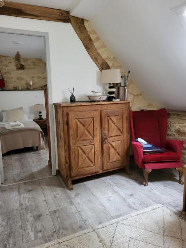 Cette chambre comprend une armoire en bois et une chaise rouge. dans l'établissement La Renardiere, au Vigan