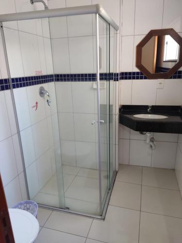 a bathroom with a glass shower and a sink at Hotel São Luiz in Aparecida