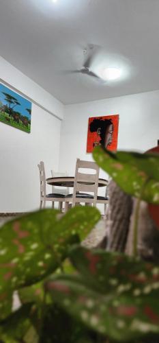 a room with a table and chairs and a plant at Ocean Breeze Homes 1, 2 or 3 bedroom Watamu in Watamu