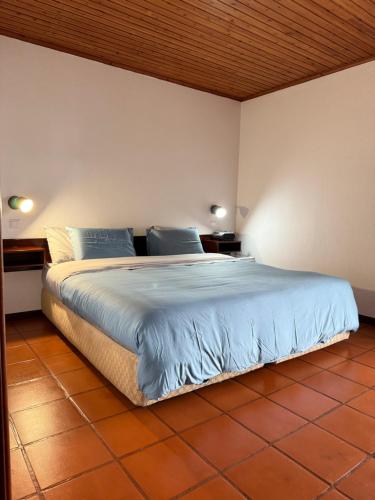 a bedroom with a large bed with blue sheets at Habitación con estacionamiento y baño privado in Funchal