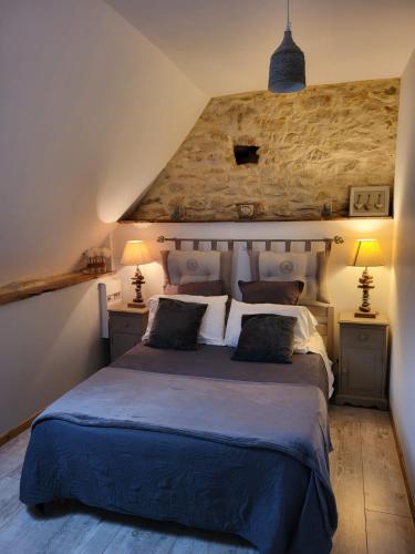 une chambre avec un grand lit avec deux lampes dans l'établissement La Renardiere, au Vigan