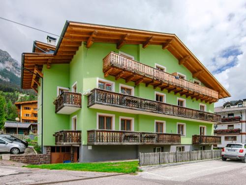 a green building with wooden balconies on it at Apartment Saslench by Interhome in Pera