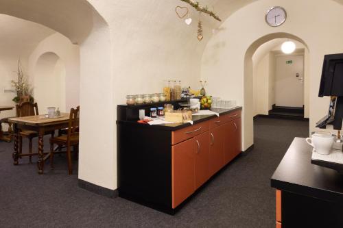a kitchen with a counter and a table and a clock at Hotel Villa-Bassermann, stilvoll, 2 Min zum Schloss, schnelles WLAN & Parkplatz in Schwetzingen