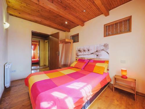 a bedroom with a colorful bed with a wooden ceiling at Chalet Mare e Monti by Interhome in Antona