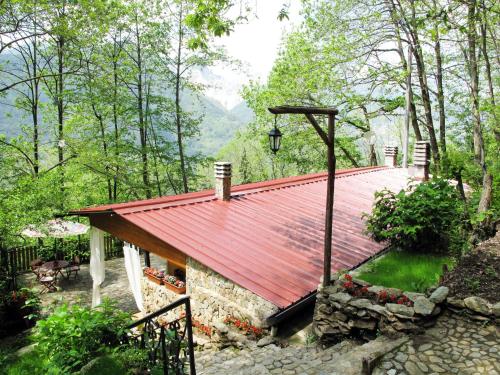 a house with a red roof in the woods at Chalet Mare e Monti by Interhome in Antona