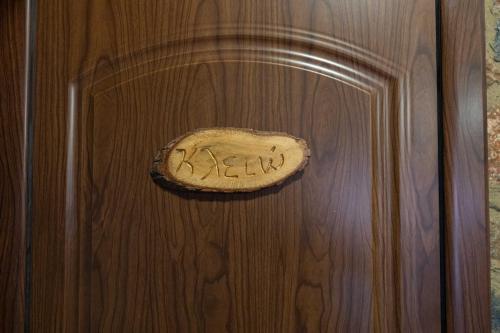 a wooden door with a plaque on it with the word okay at Suites Mouses in Palaios Agios Athanasios