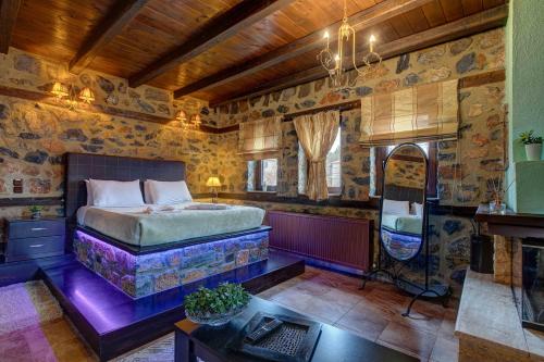 a bedroom with a bed and a desk in a room at Suites Mouses in Palaios Agios Athanasios