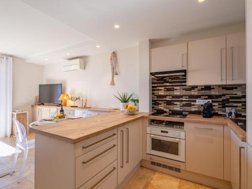 une cuisine avec des armoires blanches et un comptoir en bois dans l'établissement Holiday Home Le Bougainvillier by Interhome, à Sainte-Maxime