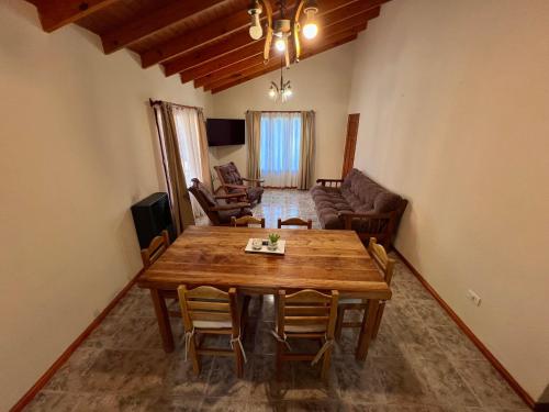 a living room with a wooden table and chairs at Hosteria Yamile in El Calafate