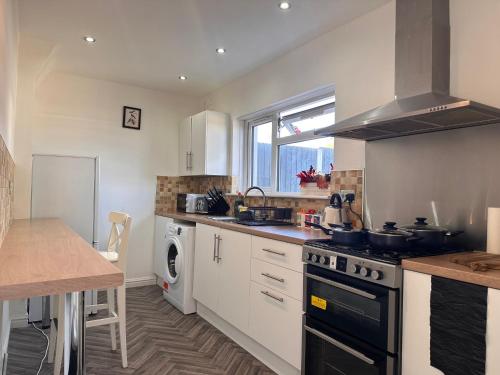 a kitchen with a sink and a stove top oven at Cozy 3 Bedroom House For Short and Long Stay in Lower Gornal