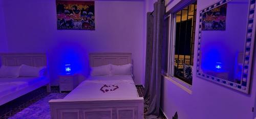 a purple room with a bed and a window at Ocean Breeze Homes 1, 2 or 3 bedroom Watamu in Watamu