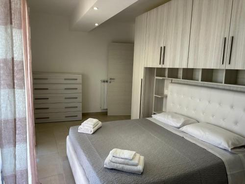 a bedroom with a large bed with two towels on it at Beautiful Apartment with Swimming Pool in Olbia