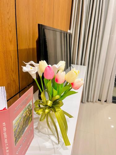 a vase of flowers sitting on a table at Châu Giang Homestay, Nera Garden Huế in Thôn Văn Dương