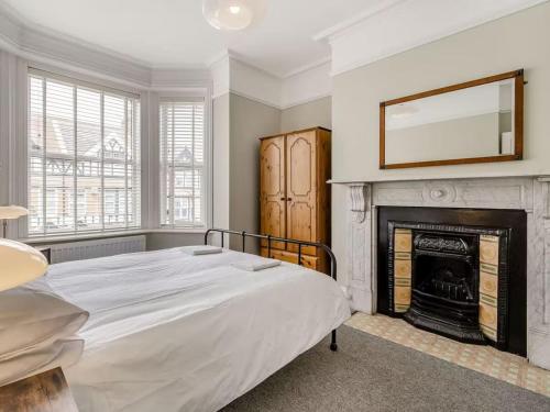 a bedroom with a bed and a fireplace at Coastal Apartment 2 Minutes from the Beach & Town Centre in Cromer