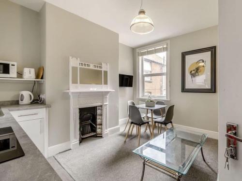 a living room with a table and a fireplace at Coastal Apartment 2 Minutes from the Beach & Town Centre in Cromer