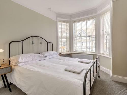 a bedroom with a large bed with white sheets and pillows at Coastal Apartment 2 Minutes from the Beach & Town Centre in Cromer
