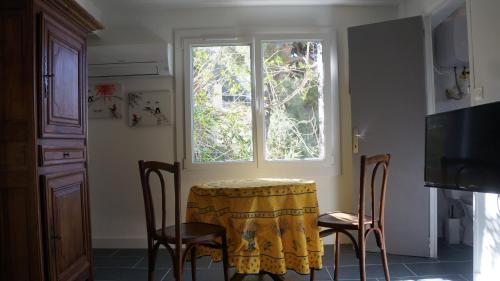 une cuisine avec une table et des chaises et une fenêtre dans l'établissement Charming seaside condo, à Ensuès-la-Redonne