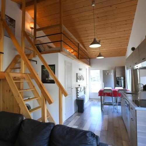 un salon avec un escalier et une cuisine dans l'établissement Gîtes Shamsoka - Haras de Séranon, à Séranon