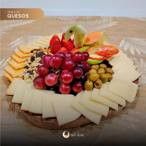 a plate of cheese and fruit on a table at Hotel Zensual in Bogotá