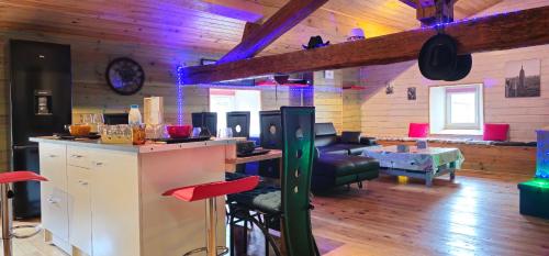 une cuisine et un salon avec un bar dans une pièce dans l'établissement Le refuge en campagne country, à Nébias