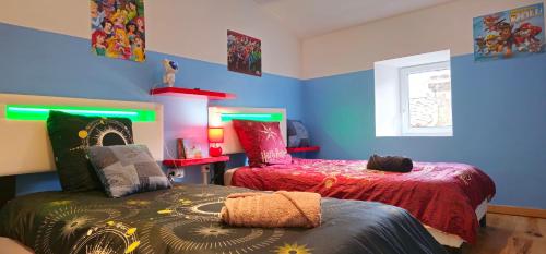 - une chambre avec 2 lits et des murs bleus dans l'établissement Le refuge en campagne country, à Nébias