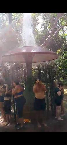 a group of men standing under a large umbrella at Apartamento Gracioso ao lado do Parque das Águas in Caxambu