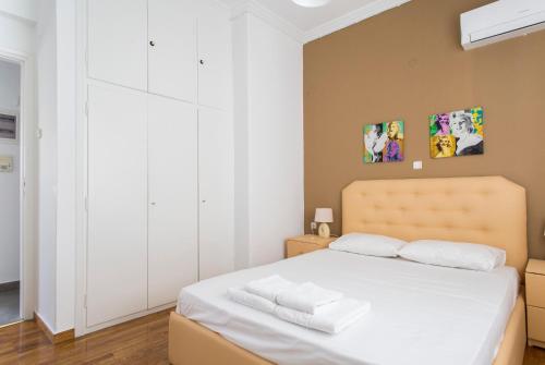 1 dormitorio con 1 cama blanca y armarios blancos en Pedion Areos Park 4 Center 4, en Atenas