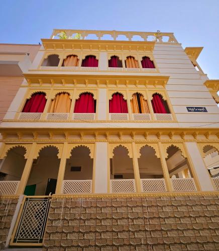 a tall building with red curtains on it at Nikunj Mahal Homestay in Udaipur