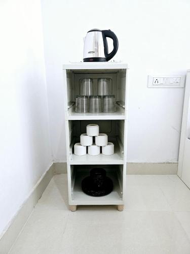 a shelf in a kitchen with a tea kettle on top at Nikunj Mahal Homestay in Udaipur
